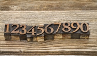 Number abstract in vintage letterpress wood type against grained wooden plank