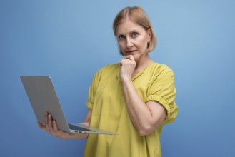 Pensive middle aged business woman freelancing using laptop and internet connection