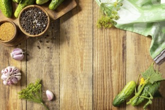 Wooden background with cucumbers prepared for pickling and ingredients for the marinade. Canned