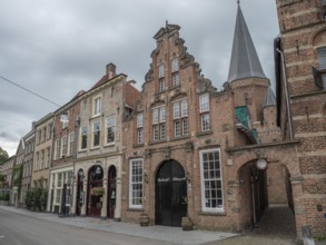 Historic houses and a church tower in a quiet street under a cloudy sky, zutphen, gelderland,