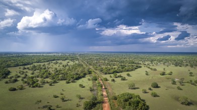 Aerial view of Transpantaneira dirt road with dramatic sky and rain crossing the typical landscape