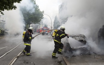 Fire brigade extinguishes burning cars on the Elbchaussee in Hamburg after the riots at the G20