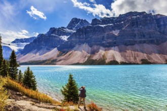 The Majestic Rockies of Canada. A gray-haired tourist photographs a grandiose landscape. Lake Bow