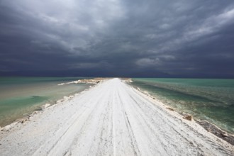 Sunset. Incredible lighting effects in a thunderstorm at the Dead Sea. The road in the middle of