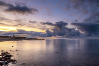 Atmospheric sunset landscape at the seaside with clouds and a lighthouse. Soft light at the sunset