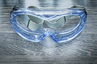 Safety plastic goggles on wooden board