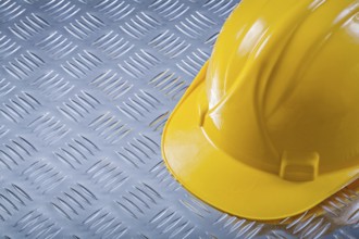 Safety hard hat on channeled metal background construction concept