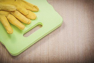 Safety leather gloves garden foam kneeling pad on wooden board gardening concept