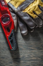 Construction level protective gloves on wooden board