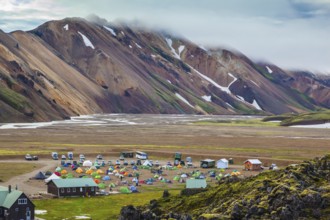 Pink and green rhyolite mountains surround the flat valley of the National Park Landmannalaugar.