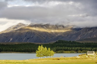 Sun breaking through the clouds over Lake Tekapo and the Church of the Good Sheppard on the South