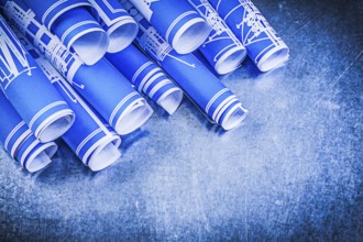 Pile of blue blueprints on metallic background construction concept