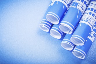 Stack of engineering drawings on blue background top view