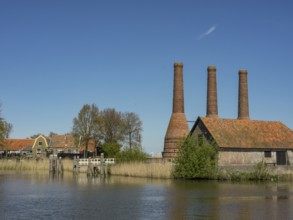 Old factory site with three tall chimneys on the waterfront, enkhuizen, the netherlands