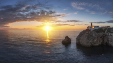 Portuguese coast with a lighthouse in the rays of the setting sun, Cabo De Sao Vincente on sunset
