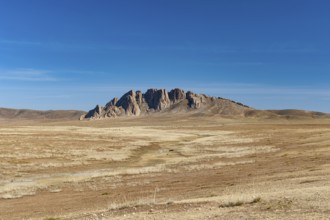 Rock formation on the horizon in the steppe landscape of the Gobi Desert, Mongolia, Central Asia