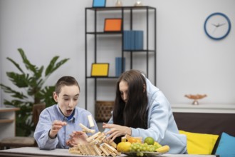 Eine Gruppe von Kindern ist mit einem spannenden Jenga-Spiel beschäftigt, bei dem sie ihre