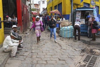 Antananarivo, Madagascar - April 24, 2019: Two unknown young Malagasy girls walking cobblestone