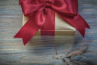 Present box in glittery paper on vintage wooden board holidays concept