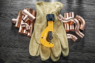 Plumbing water pipe scissors leather safety gloves on wooden board top view