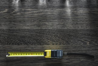 Rolled tape measure on vintage wooden board