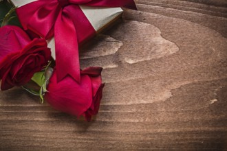Wrapped present with red ribbon natural bloomed roses holiday concept