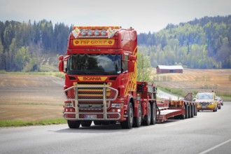 Scania truck of PHP Group in front of gooseneck trailer returns from delivering oversize load,