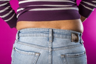 Woman with jeans shows her belly. Overweight
