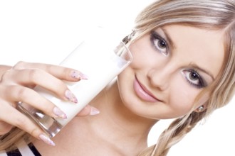 Beautiful woman drinking milk on a white background