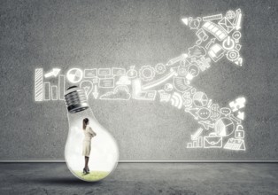 Businesswoman inside of light bulb in empty concrete room