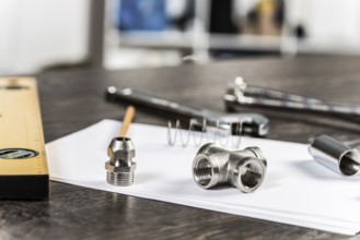 Water braided metal hose and hosepipe fittings laying on table. Close up flexible hydraulic system.