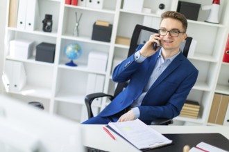 Casual businessman working in office, sitting at desk, typing on keyboard, looking at computer