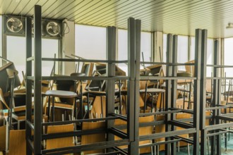 Goesan, South Korea. May 29, 2020: Chairs and tables stacked haphazardly in sunlit room of bankrupt