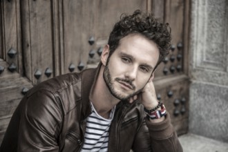 Attractive young man outdoor wearing leather jacket, in European city, Turin in Italy