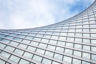 Abstract modern architecture, glass exterior structure, wave shape building detail in blue sky