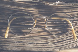 Old vintage round glasses and old book. Low light