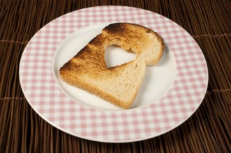 Toast with heart-shaped set in white plate
