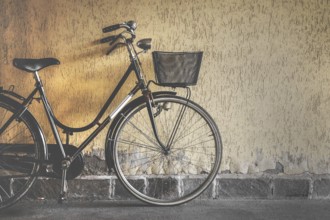 Vintage bicycle leaning against a wall. Retro style photo