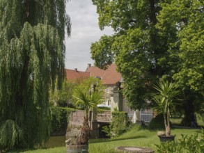 Historic building surrounded by green garden and trees, havixbeck, germany
