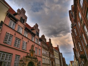 View of historic house facades in a narrow street under a dramatic sky, lübeck, schleswig-holstein,