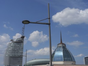 Modern buildings with glass facades under a blue sky with some clouds and lanterns in the