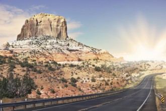 Gorgeous American Highway. Monument Valley in Utah on a cloudy windy day. Shining rays of evening