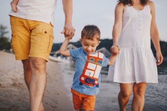 Family holiday in summer. Young Caucasian family foot walking barefoot sandy beach, shore river