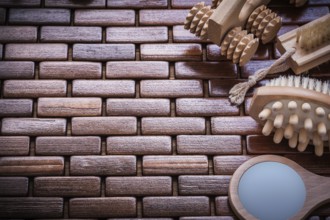 Looking-glass massagers and peeling brushes on textured wooden table mat sauna concept
