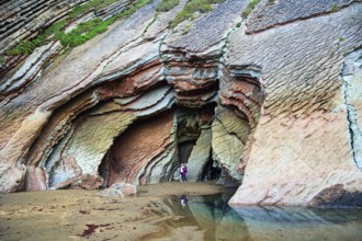 Huge cave on the beach. Low tide in the Atlantic. Flysch - unique landscape of underwater rocks