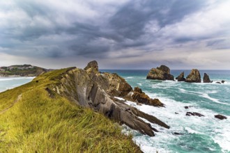 Rocky coastline of the Atlantic Ocean. Spanish coast, Cantabria. Portio beach. Stormy autumn day in