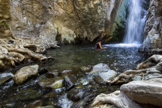 Unrecognised woman swimming in the natural pool of Millomeri waterfalls Platres, Troodos, Cyprus