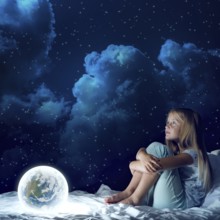Cute girl sitting in bed and looking at Earth planet. Elements of this image are furnished by NASA