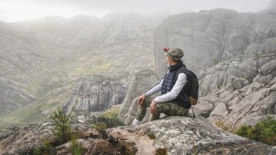 Young woman in sports clothing sitting on rocks enjoying the scenery of Andringitra national park,