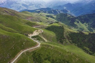 Aerial view of road in Caucasus mountains, Road running through green hills